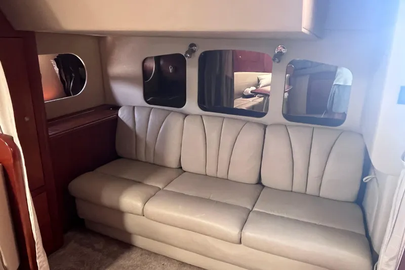 Slide: The Image of 2007 Cruisers Yachts 370 Express interior with beige sofa and mirrored wall accents. - 23