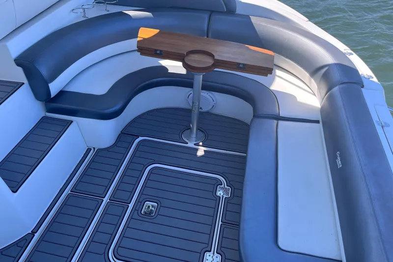 Slide: The Image of 2007 Cruisers Yachts 370 Express interior with curved seating and wooden table. - 7