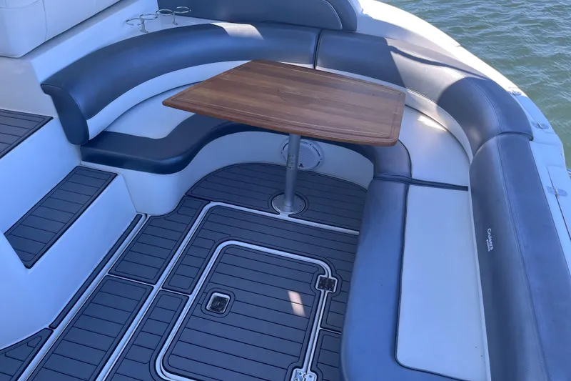 Slide: The Image of 2007 Cruisers Yachts 370 Express seating area with wooden table and cushioned seats. - 8