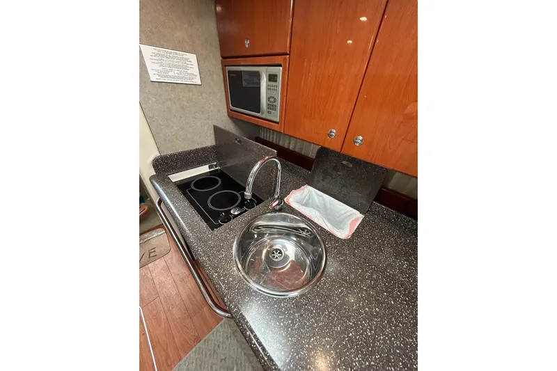 Slide: The Image of 2008 Formula 34 Performance Cruiser interior with kitchenette, wood cabinets, and modern appliances. - 16