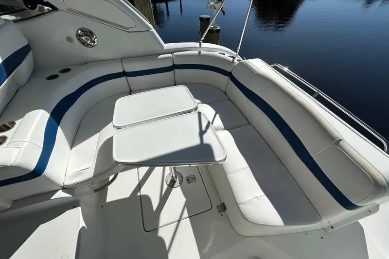 Slide: The Image of 2008 Formula 34 Performance Cruiser interior with white and blue seating, dual tables, and water view. - 2