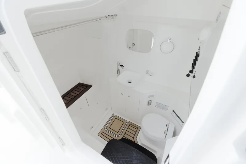 Slide: The Image of 2026 World Cat 400DC-X Island boat bathroom interior, featuring sink, toilet, and mirror. - 9
