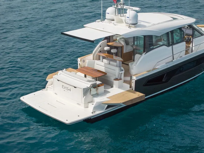 Slide: The Image of Tiara Yachts EX 54, 2025 model, luxury yacht on clear blue water. - 6