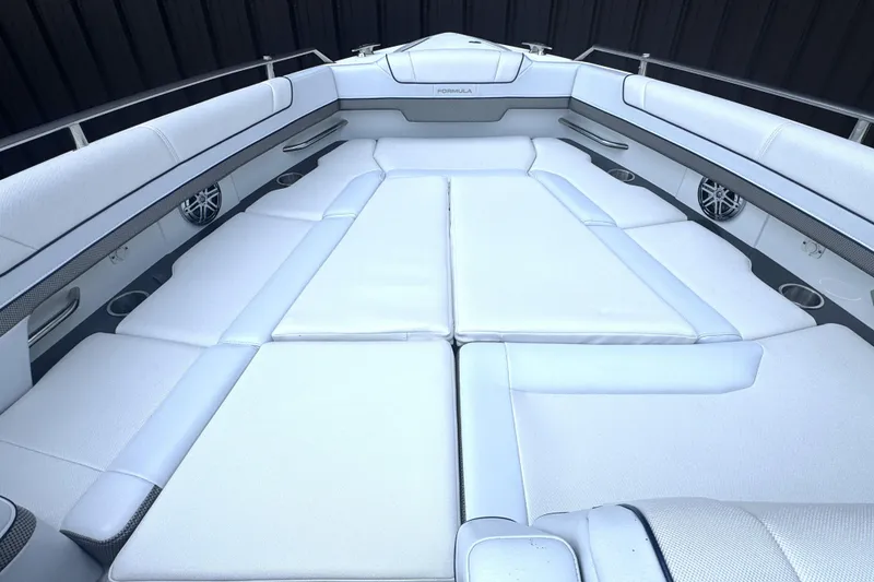 Slide: The Image of 2020 Formula 330 Crossover Bowrider with open storage compartment, white seating, and deck view. - 21