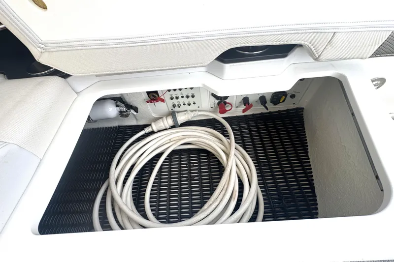 Slide: The Image of Storage compartment of 2020 Formula 330 Crossover Bowrider with coiled cable and controls. - 32