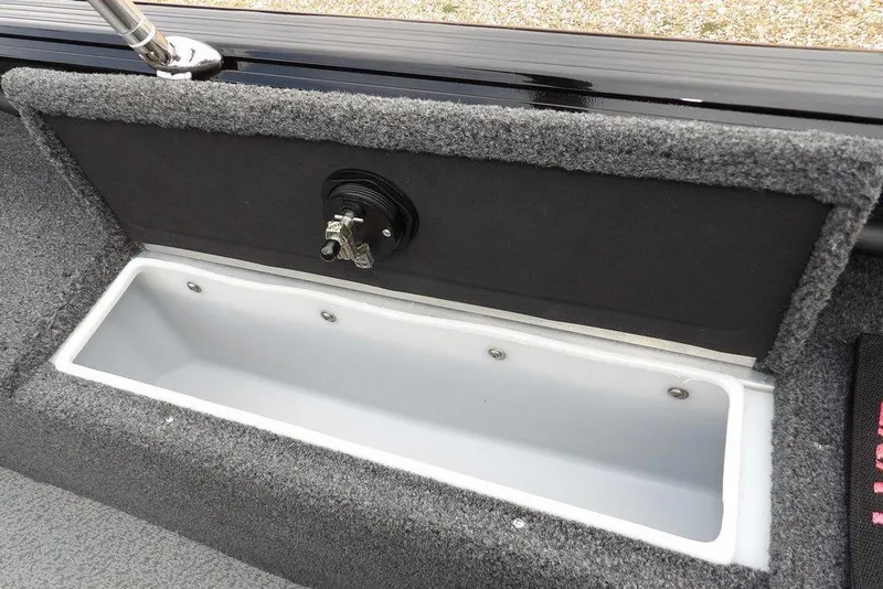 Slide: The Image of 2022 Lund 1875 Impact Sport boat storage compartment with carpeted interior and secure latch. - 14