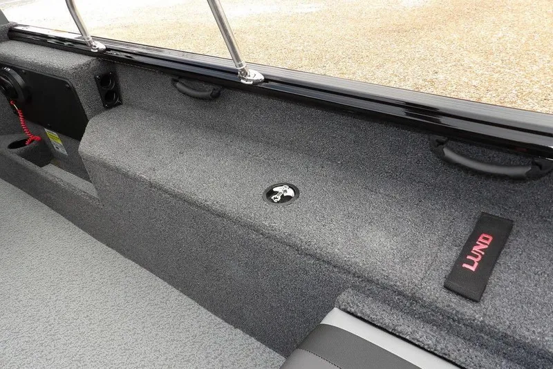 Slide: The Image of 2022 Lund 1875 Impact Sport boat interior with carpeted storage and handle. - 16