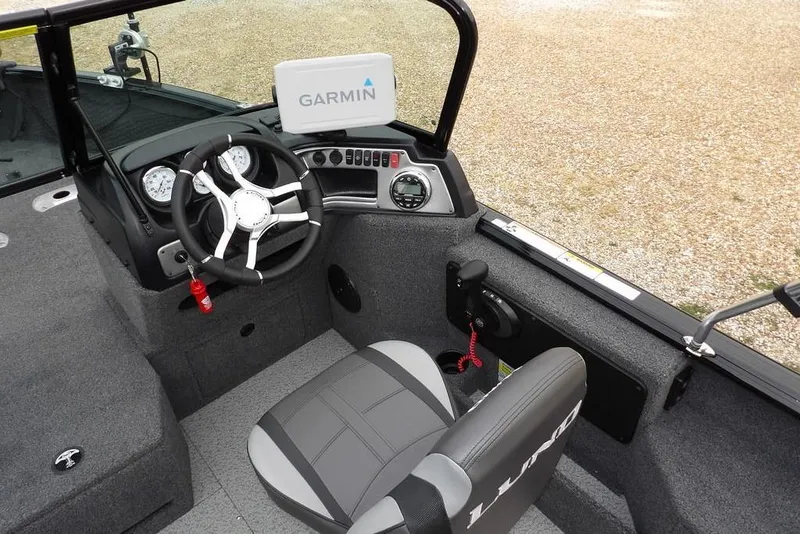 Slide: The Image of 2022 Lund 1875 Impact Sport boat interior with Garmin navigation system and steering wheel. - 24
