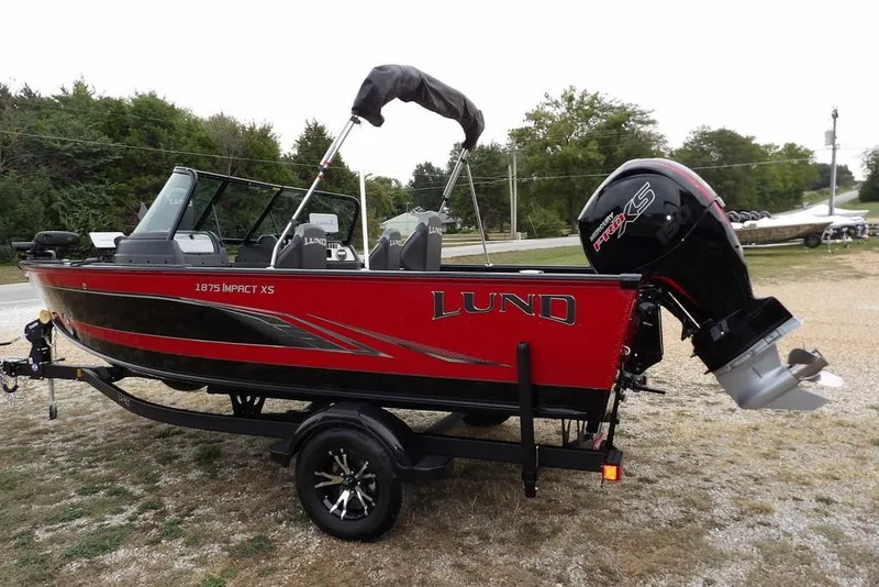 Slide: The Image of 2022 Lund 1875 Impact Sport boat in red and black on a trailer. - 3
