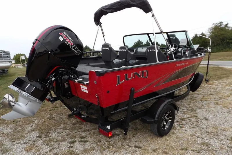 Slide: The Image of 2022 Lund 1875 Impact Sport boat with Mercury engine, red and black design, on trailer. - 4