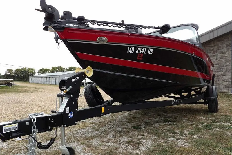 Slide: The Image of 2022 Lund 1875 Impact Sport boat on trailer, red and black design, parked outdoors. - 45