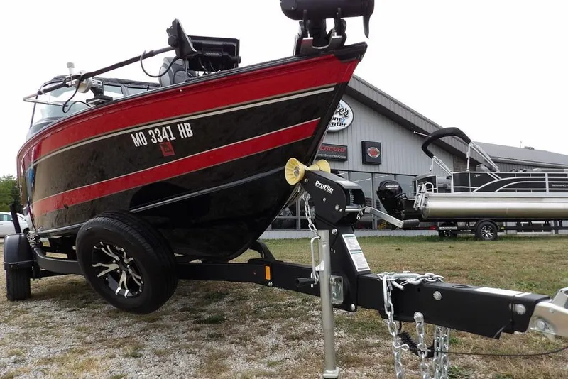 Slide: The Image of 2022 Lund 1875 Impact Sport boat on trailer, parked outside a marine center. - 47