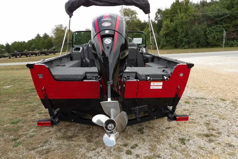 Slide: The Image of 2022 Lund 1875 Impact Sport boat, rear view with outboard motor, parked on gravel. - 5