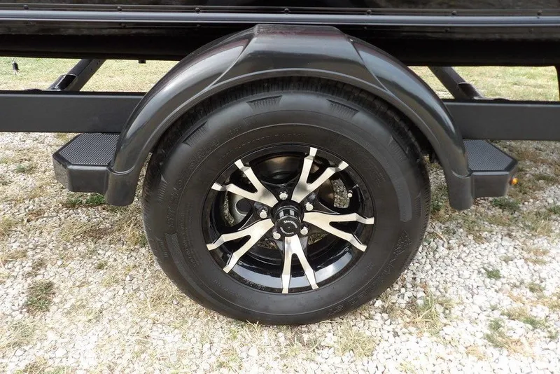 Slide: The Image of 2022 Lund 1875 Impact Sport trailer wheel on gravel surface. - 50