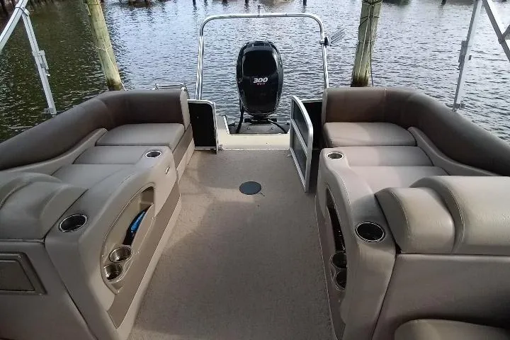Slide: The Image of 2013 Premier 290 Grand Isle pontoon boat interior with seating and outboard motor. - 7