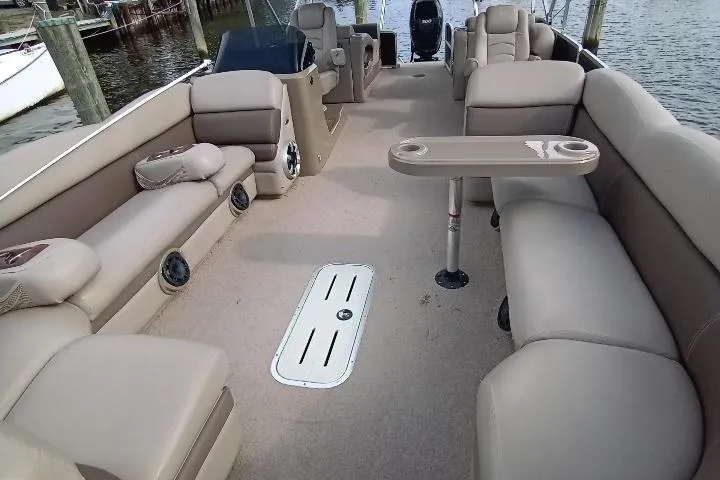 Slide: The Image of 2013 Premier 290 Grand Isle pontoon boat interior with beige seating and table. - 8
