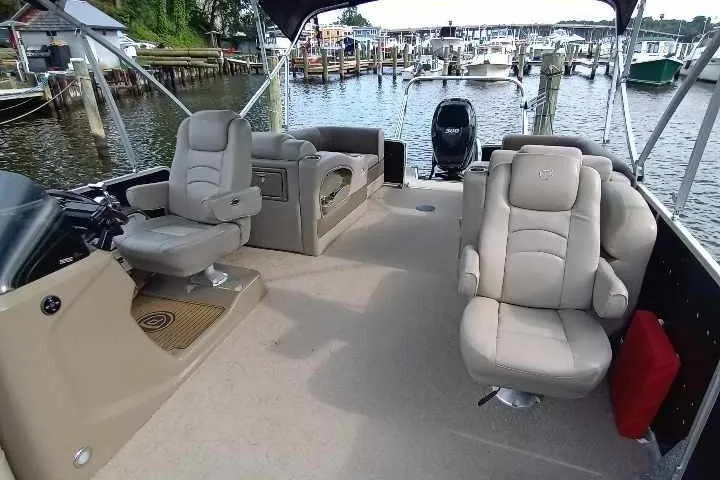 Slide: The Image of 2013 Premier 290 Grand Isle boat interior with plush seating, docked at a marina. - 9