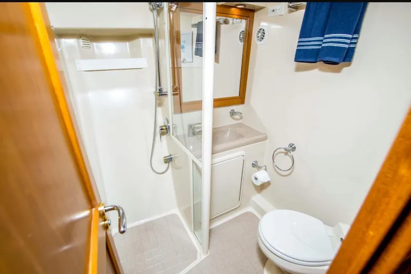 Slide: The Image of Bathroom interior of 2000 Riviera 48 Enclosed Flybridge yacht, featuring shower and toilet. - 14