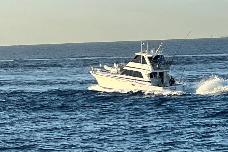 Slide: The Image of 2000 Riviera 48 Enclosed Flybridge cruising on open ocean waters. - 15