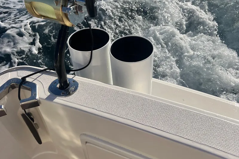 Slide: The Image of Riviera 48 Enclosed Flybridge 2000 boat deck with fishing rod holders and ocean waves. - 19