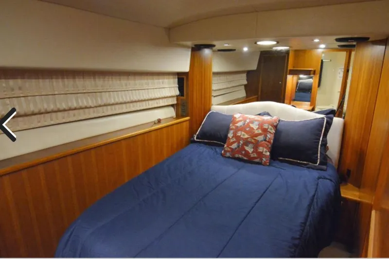 Slide: The Image of Luxurious bedroom interior of 2000 Riviera 48 Enclosed Flybridge yacht with blue bedding. - 8