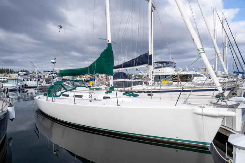 The Image of 2000 J Boats J/120 sailboat docked at a marina under cloudy skies. - 0