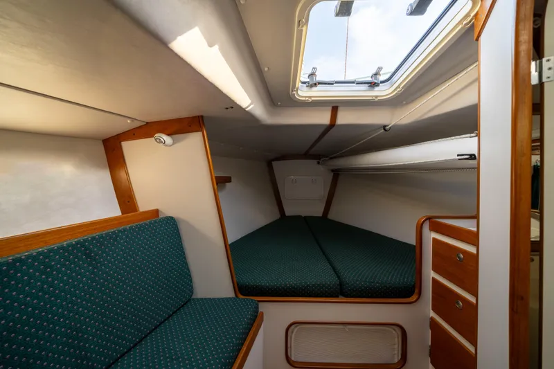 Slide: The Image of Cozy cabin interior of 2000 J Boats J/120 sailboat with green upholstery and wooden accents. - 12