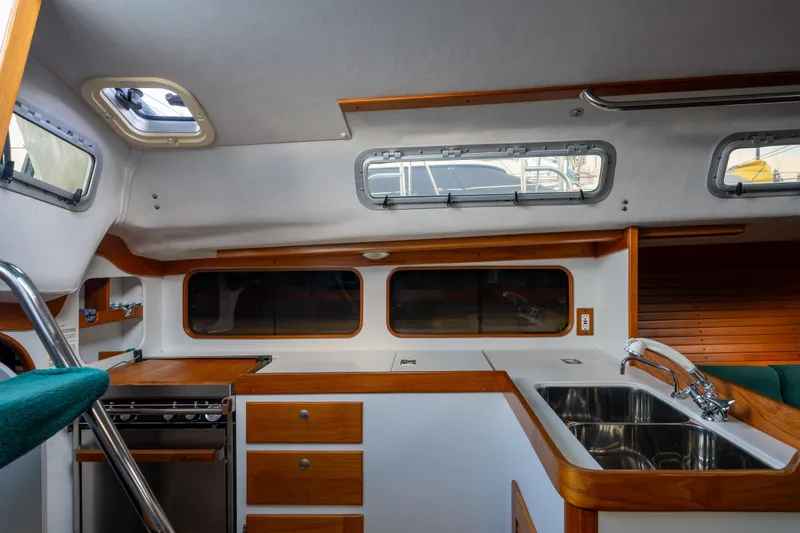 Slide: The Image of Interior of 2000 J Boats J/120 yacht, featuring a modern kitchen with wood accents. - 14
