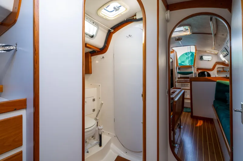 Slide: The Image of Interior of 2000 J Boats J/120 sailboat, featuring a compact bathroom and cozy cabin area. - 16