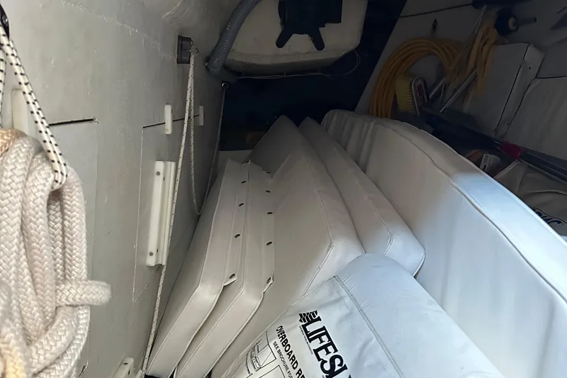 Slide: The Image of Interior of a 2000 J Boats J/120, showing stored cushions and boating equipment. - 24