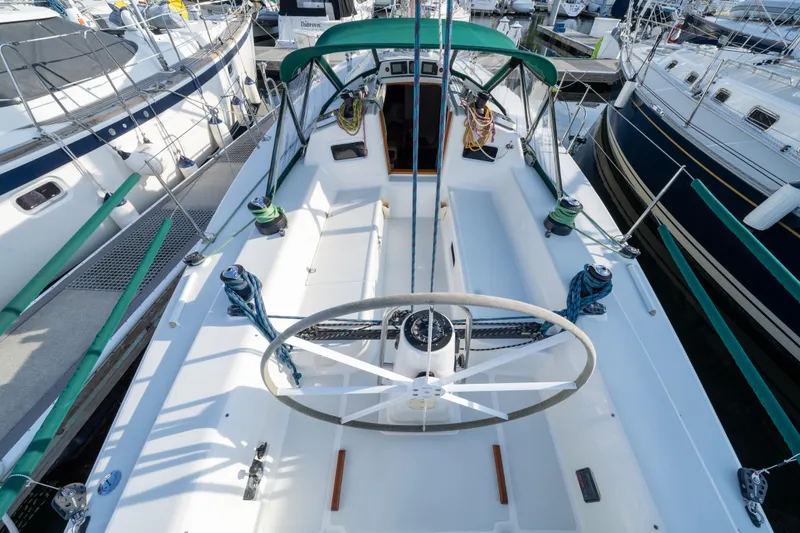 Slide: The Image of 2000 J Boats J/120 sailboat cockpit with green canopy and steering wheel at marina. - 4