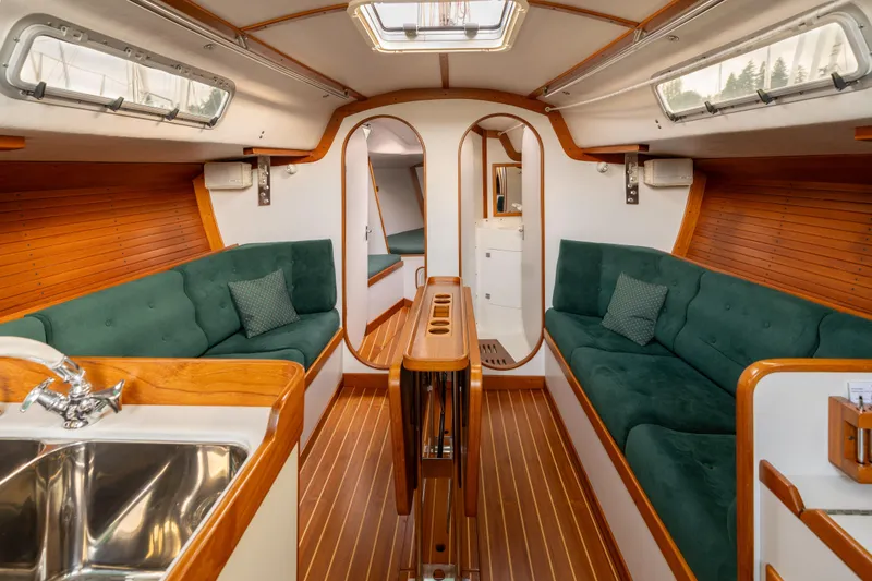 Slide: The Image of Interior of 2000 J Boats J/120 sailboat with green seating and wooden accents. - 8