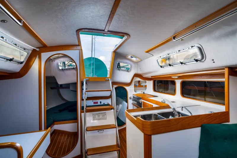 Slide: The Image of Interior of 2000 J Boats J/120 sailboat, featuring a compact kitchen and cozy cabin space. - 9