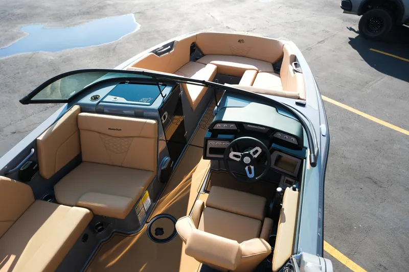Slide: The Image of 2026 MasterCraft NXT24 boat interior with tan seating and modern dashboard design. - 11