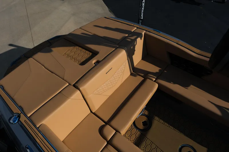 Slide: The Image of 2026 MasterCraft NXT24 boat interior with tan seating and hexagonal pattern design. - 13