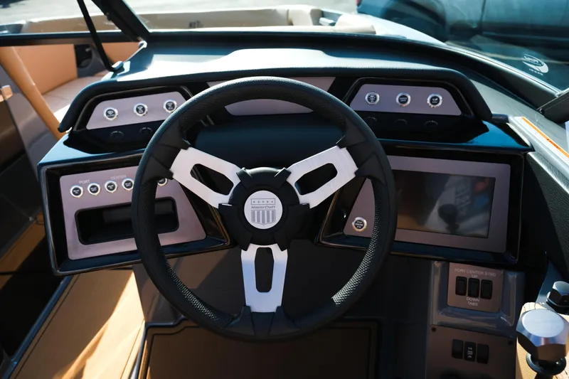 Slide: The Image of 2026 MasterCraft NXT24 boat dashboard with steering wheel and control panel. - 14