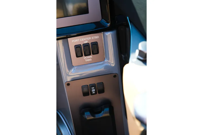 Slide: The Image of Control panel of 2026 MasterCraft NXT24 boat with tab adjustment switches. - 16