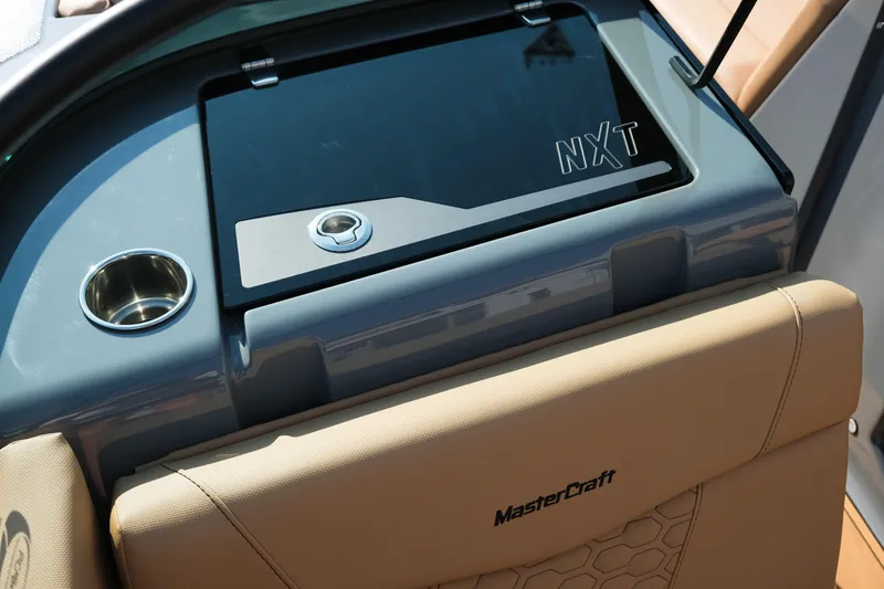Slide: The Image of 2026 MasterCraft NXT24 boat interior with cup holder and storage compartment. - 18
