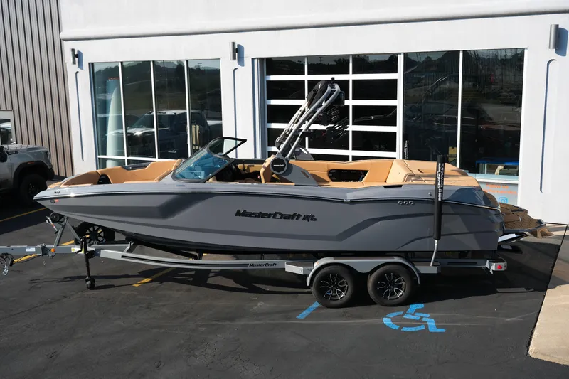Slide: The Image of 2026 MasterCraft NXT24 boat on trailer outside dealership. - 3