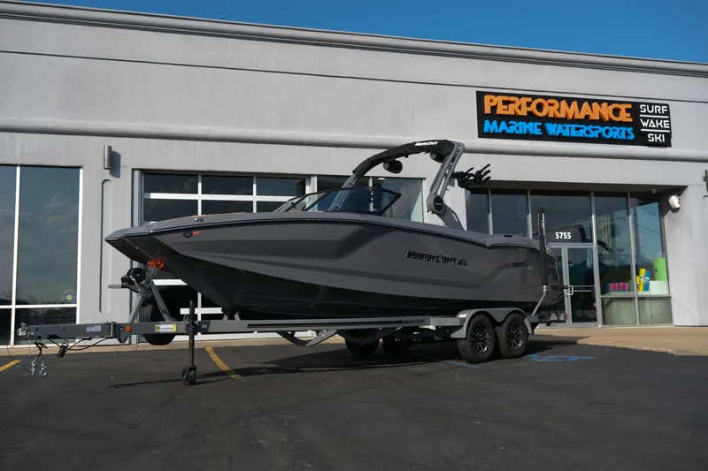 Slide: The Image of 2026 MasterCraft NXT24 boat on trailer outside marine dealership. - 32