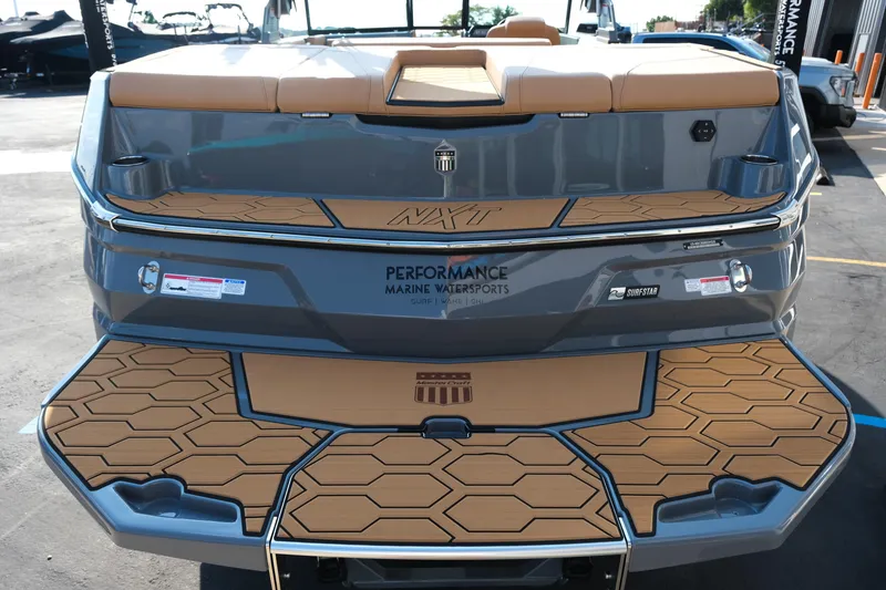 Slide: The Image of 2026 MasterCraft NXT24 boat rear view with teak-style deck and performance branding. - 6