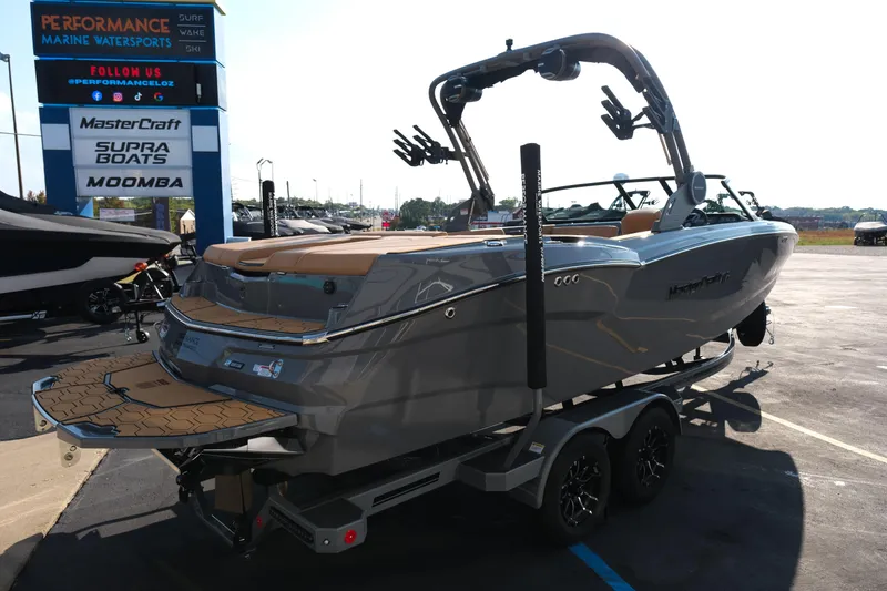 Slide: The Image of 2026 MasterCraft NXT24 boat on trailer at Performance Marine Watersports dealership. - 8
