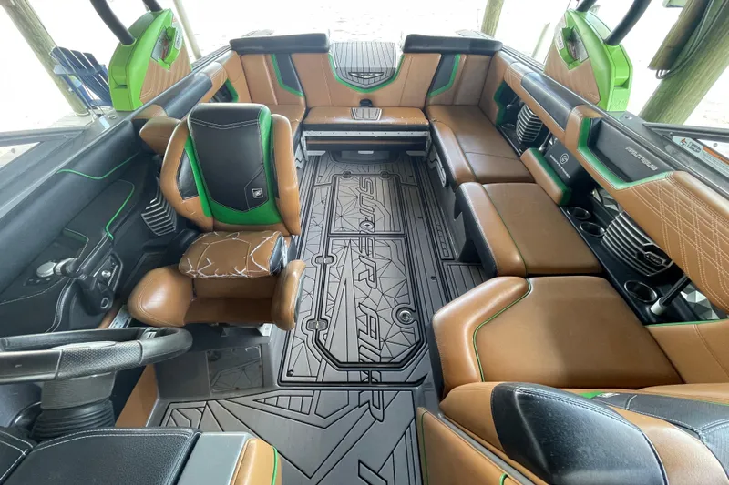 Slide: The Image of 2016 Nautique Super Air Nautique G23 Coastal Edition interior with brown and green seating. - 7