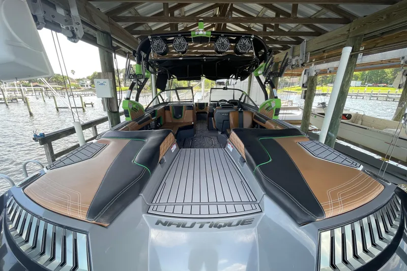 Slide: The Image of 2016 Nautique Super Air Nautique G23 Coastal Edition boat docked under a wooden shelter. - 9