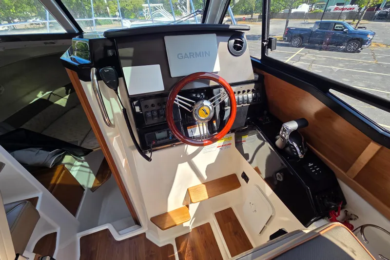Slide: The Image of 2026 Cutwater C-248 Coupe helm with Garmin navigation, wooden accents, and modern controls. - 12