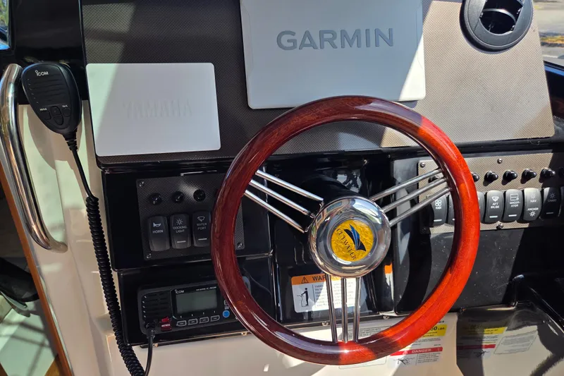 Slide: The Image of Steering wheel and controls of 2026 Cutwater C-248 Coupe boat, featuring Garmin and Yamaha equipment. - 13
