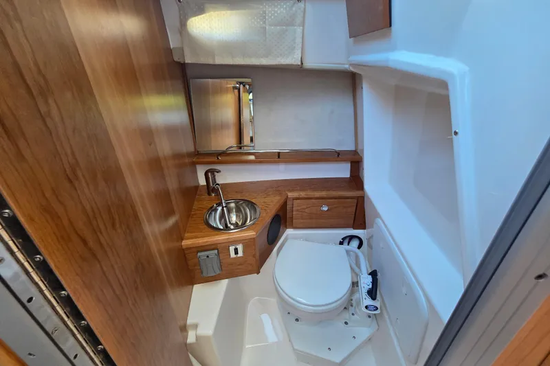 Slide: The Image of 2026 Cutwater C-248 Coupe bathroom with wooden accents, compact sink, and toilet. - 15