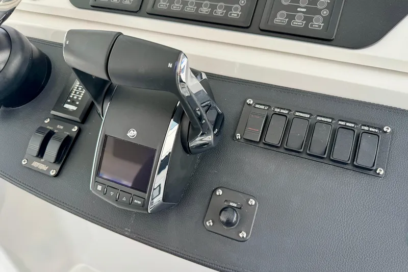 Slide: The Image of Control panel of 2026 Intrepid 50 Evolution boat with switches and throttle. - 11