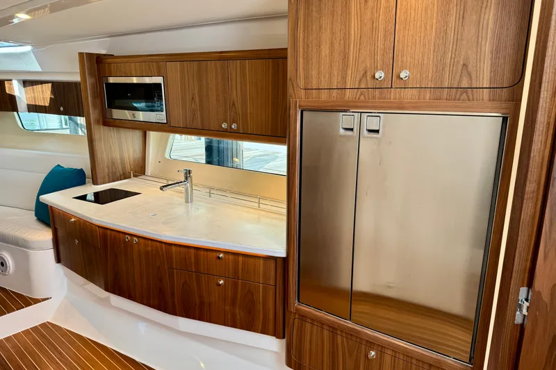 Slide: The Image of Luxurious kitchen interior of 2026 Intrepid 50 Evolution yacht with wood cabinetry and stainless appliances. - 13