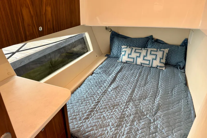 Slide: The Image of Cozy cabin interior of 2026 Intrepid 50 Evolution with blue bedding and geometric pillows. - 15